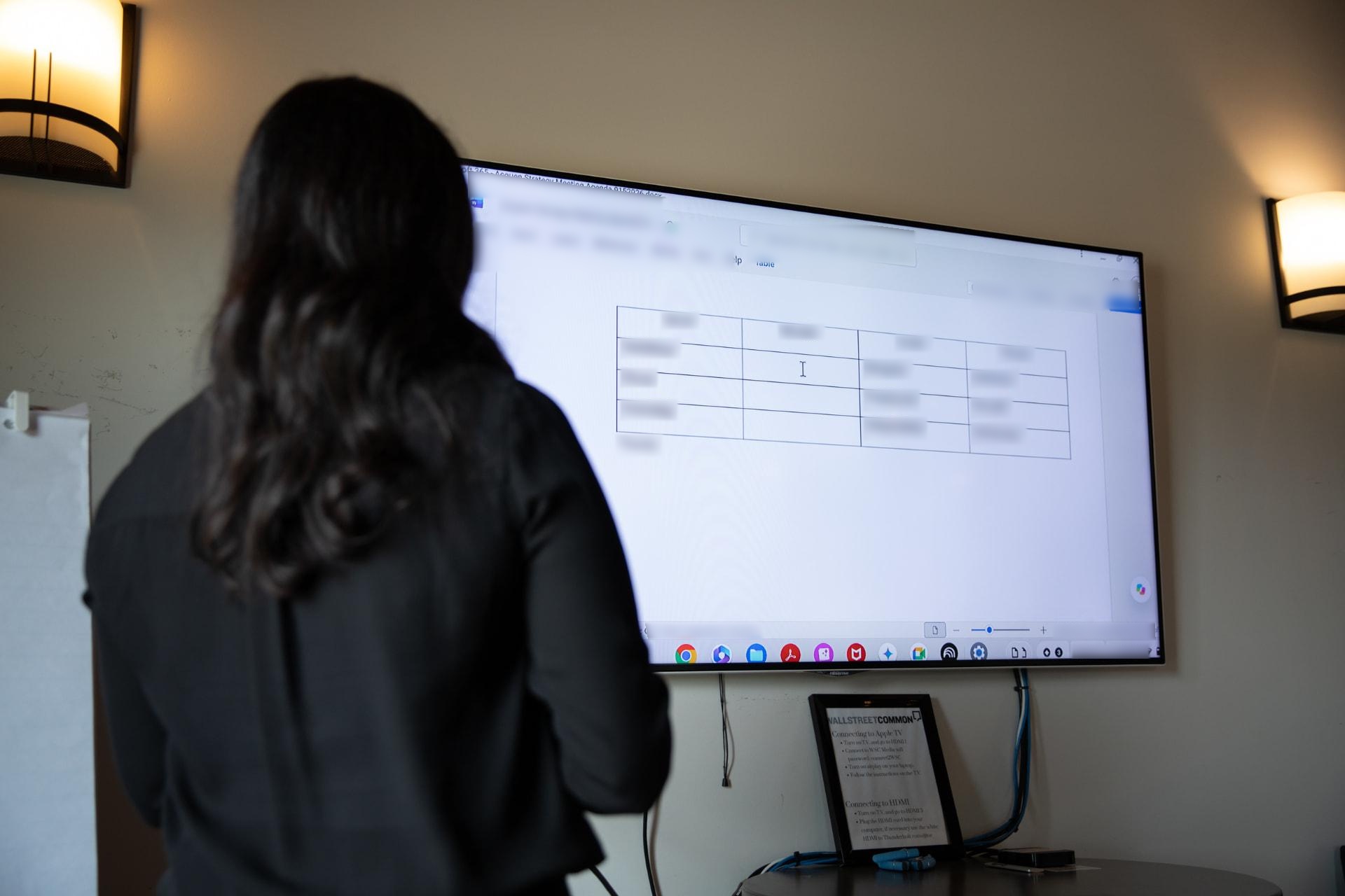 Pavan leading a strategy session, with a team's values listed on the room's screen